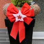 Hübsch gestaltete Weihnachtsdekoration mit rotem Tuchstern an der Haustüre