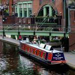 Idyllischer Kanalabschnitt mit Boot, Bruecke und Pubs