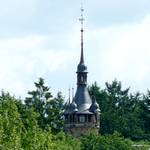 Turmspitze ragt aus dem Wald