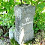 Grauer Grabstein im Wald